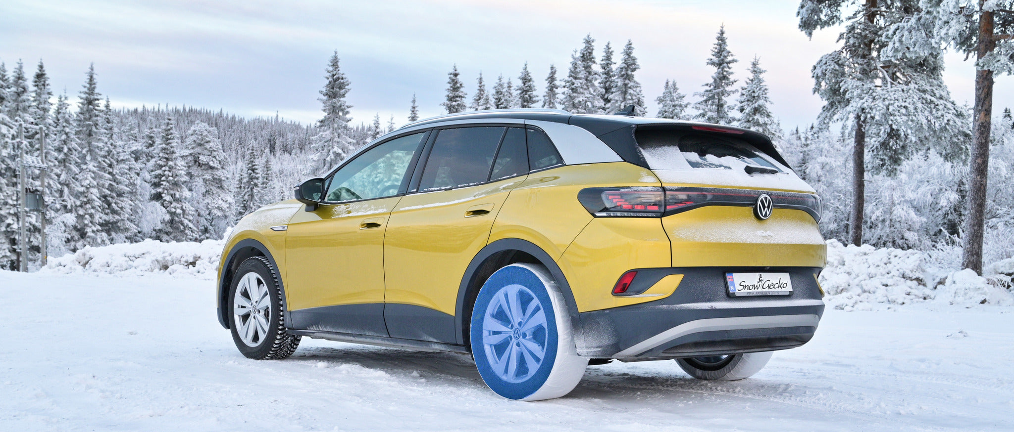 SnowGecko auf den Hinterrädern eines Volkswagens montiert, auf Schnee stehend