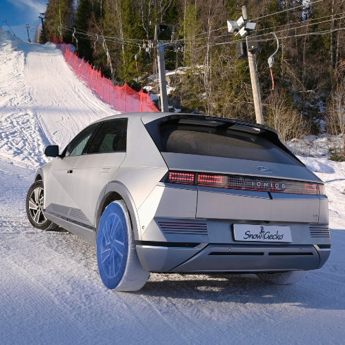 Automobil mit installierten SnowGecko Schneesocken auf den Hinterrädern 