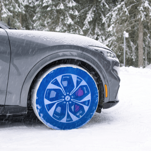 SnowGecko Reifensocken montiert auf dem Vorderreifen eines Autos im Schnee